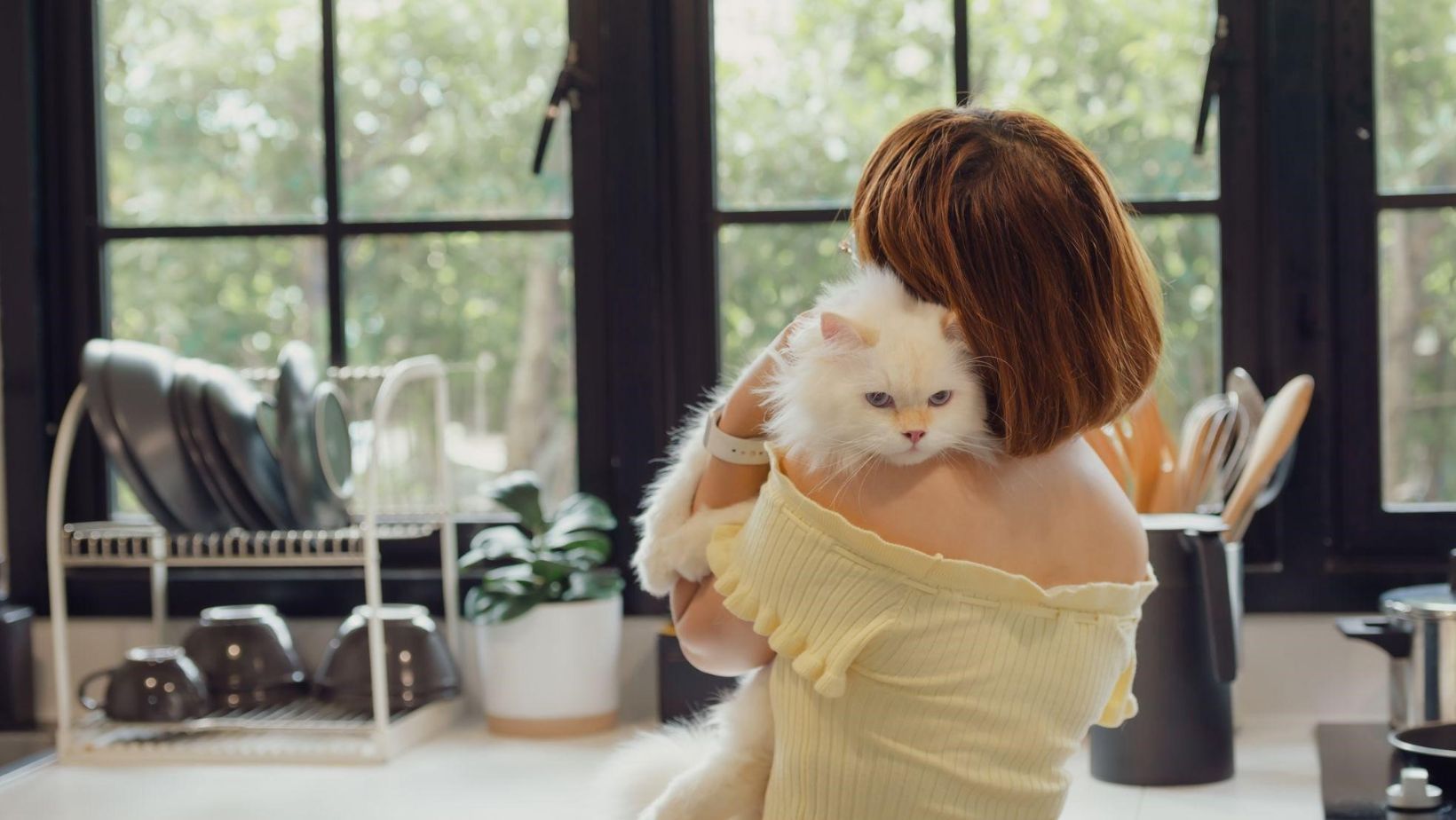 girl hugging cat in the kitchen