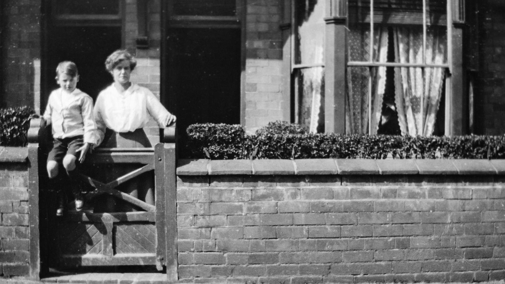Two people in front of a house.
