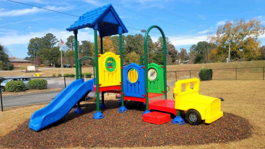 Colorful children's playground with blue slide and yellow truck