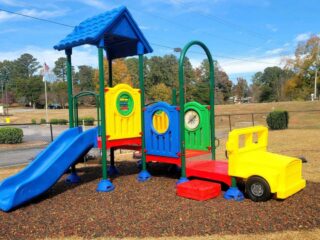 Colorful children's playground with blue slide and yellow truck