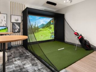Indoor golf simulator room with projection screen