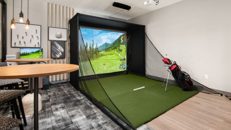 Indoor golf simulator room with projection screen