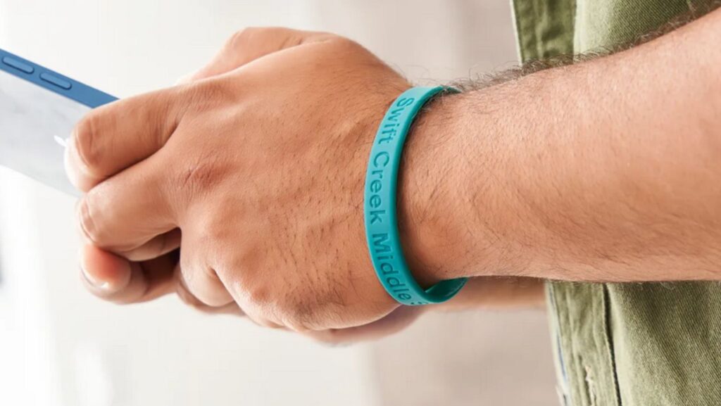 Man wearing teal colored silicone wristband