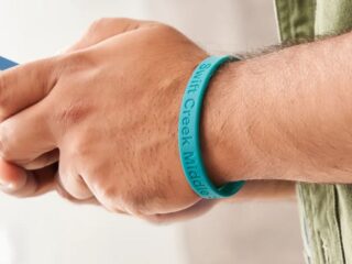 Man wearing teal colored silicone wristband
