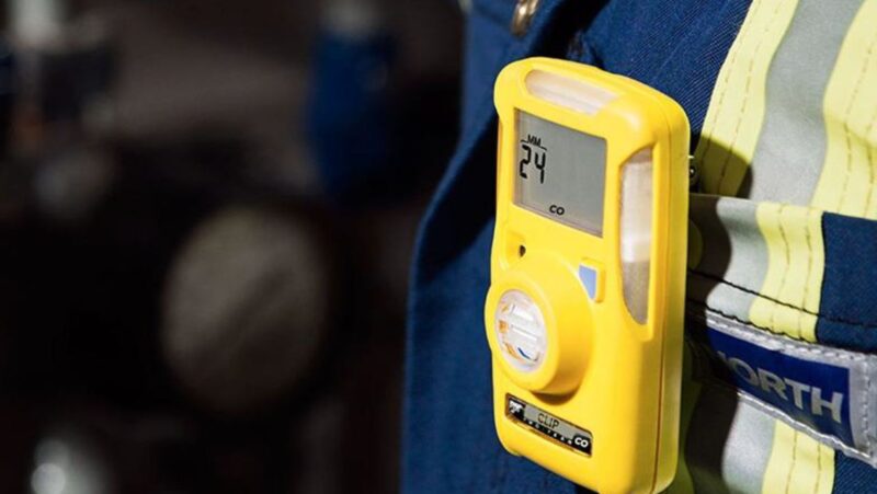Yellow portable gas detector clipped on safety vest