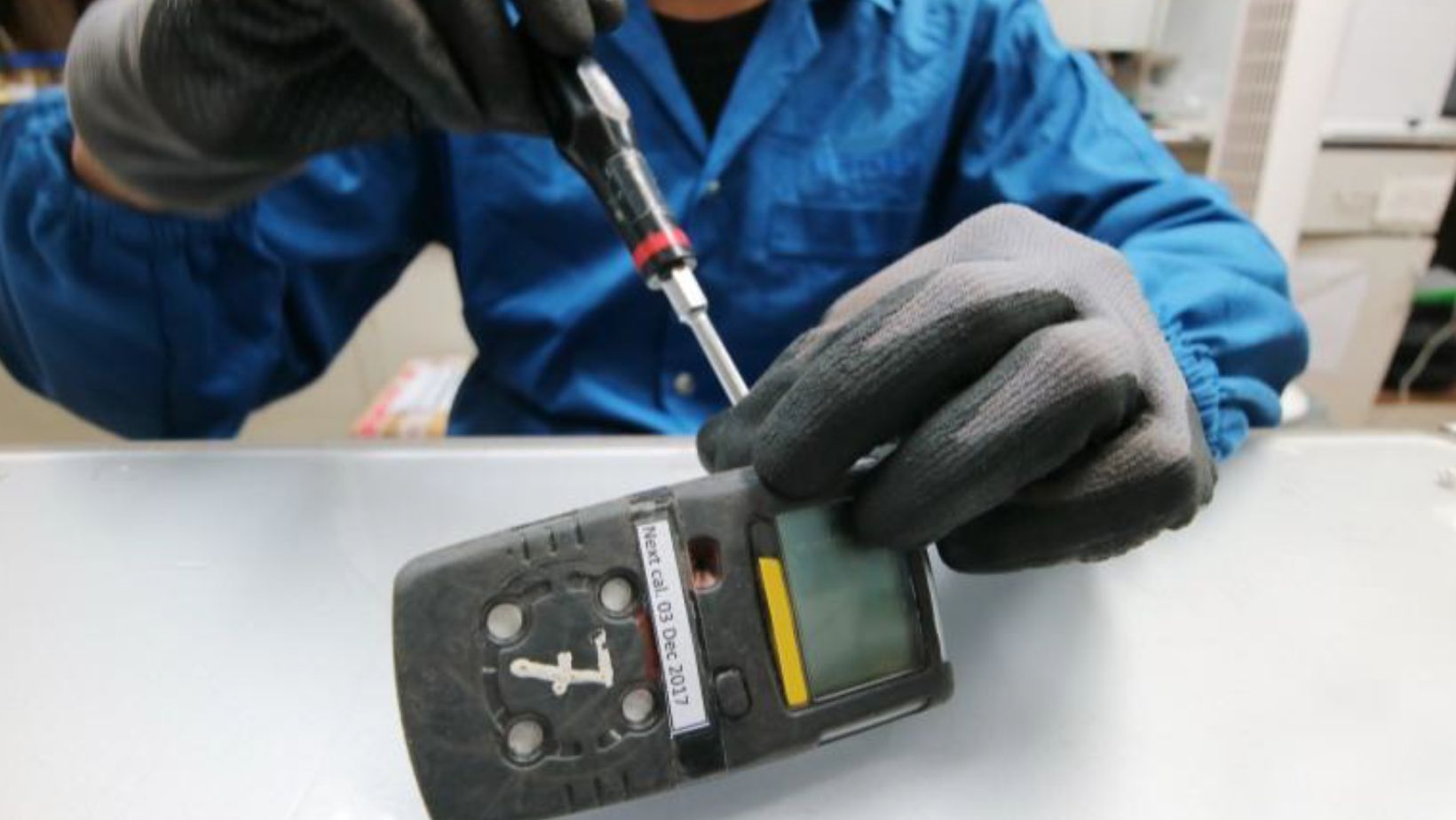 Technician repairing electronic device in blue uniform