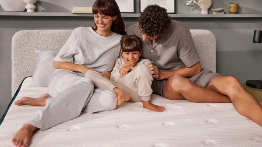 Happy family of three relaxing on bed together
