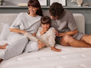 Happy family of three relaxing on bed together