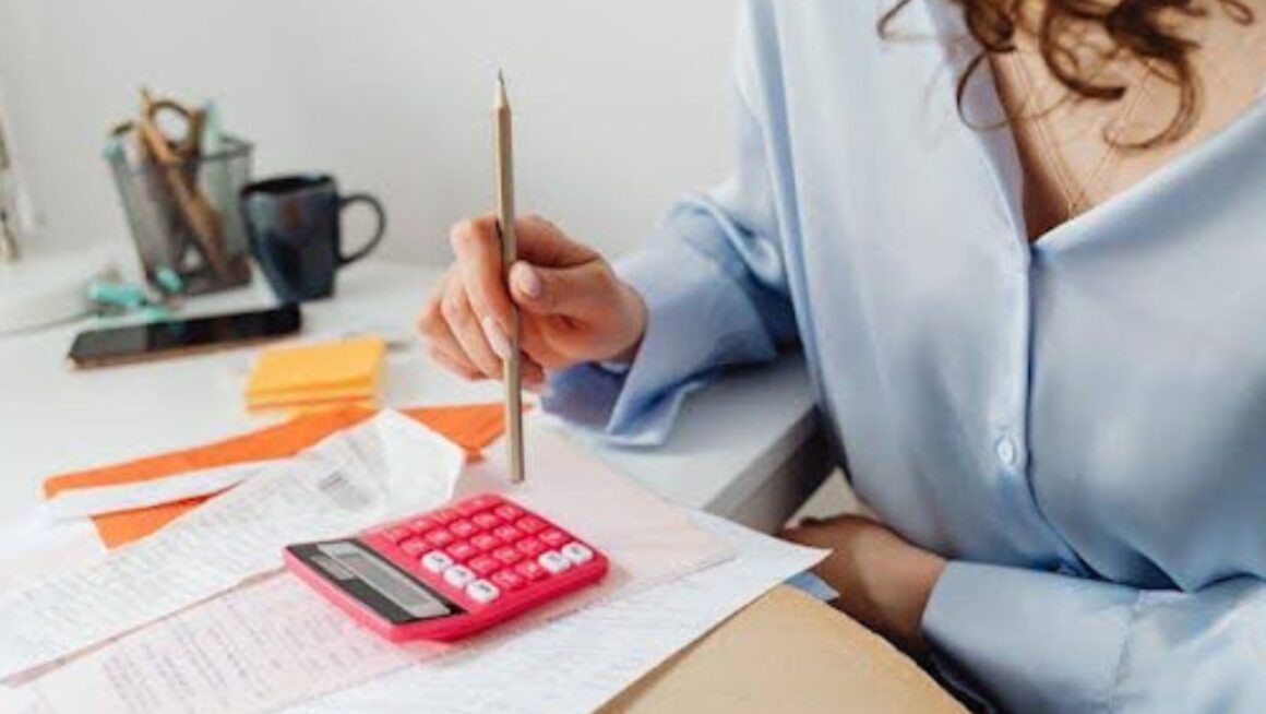 A woman using a pink calculator