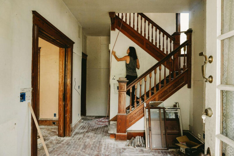 A woman renovating her house and standing on the stairs