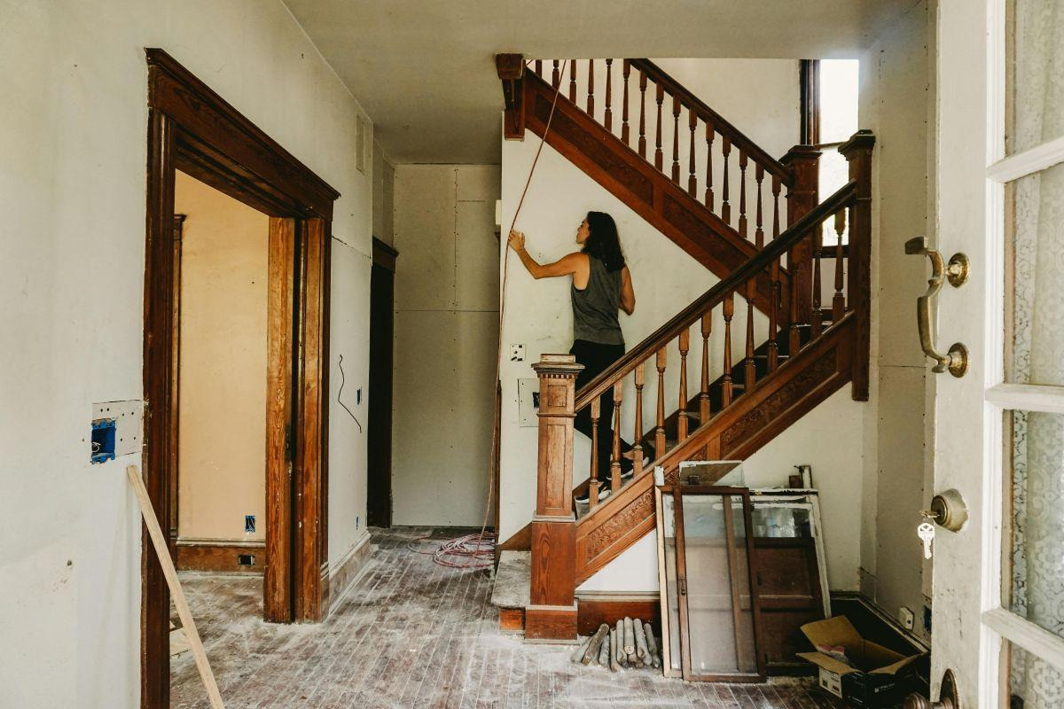 A woman renovating her house and standing on the stairs